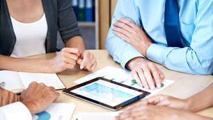 Group of professionals discussing spectrum licensing strategies and frameworks for dynamic spectrum access and spectrum sharing during a consulting meeting.