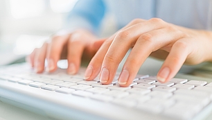 Hands typing on a keyboard represent newsletter updates on spectrum management, events and company news.