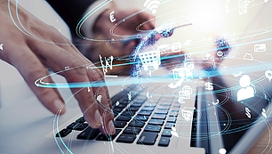 Hands use a laptop with digital logistics icons for serial number tracking with mySPECTRA NMS