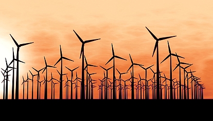 Utility Communication Networks Wind turbines at sunrise representing reliable communication networks for utilities and energy providers.