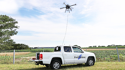 Gekoppelte AMU-Drohne für Langzeiteinsätze AMU-Drohne, die an ein Pick-up-Fahrzeug gekoppelt ist, für kontinuierliche Stromversorgung und stabile Datenverbindung bei Langzeiteinsätzen.